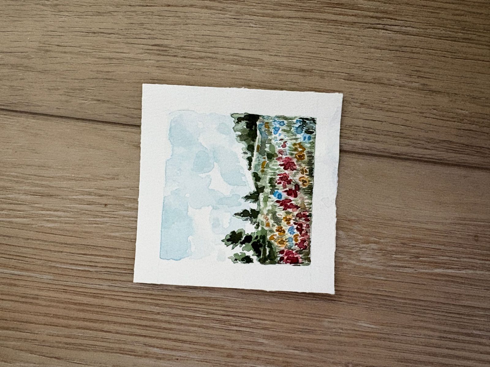 Small watercolor of trees and wildflowers